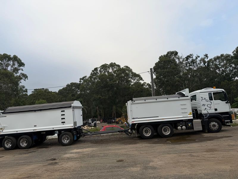 Two Mega Works white tipper trucks lined up at a Western Sydney site
