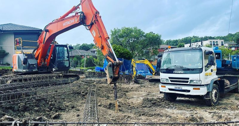 Hitachi excavator and Isuzu truck on a site preparation job