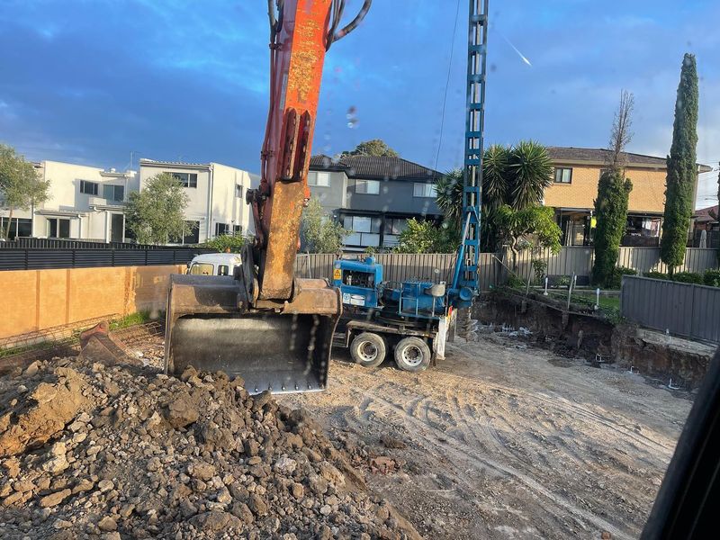 Excavator and piling rig working on a residential basement excavation site